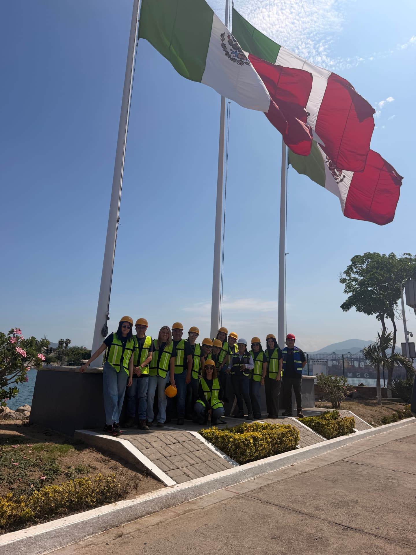 Equipo de GFS Customs en el puerto de Manzanillo frente a la bandera de México